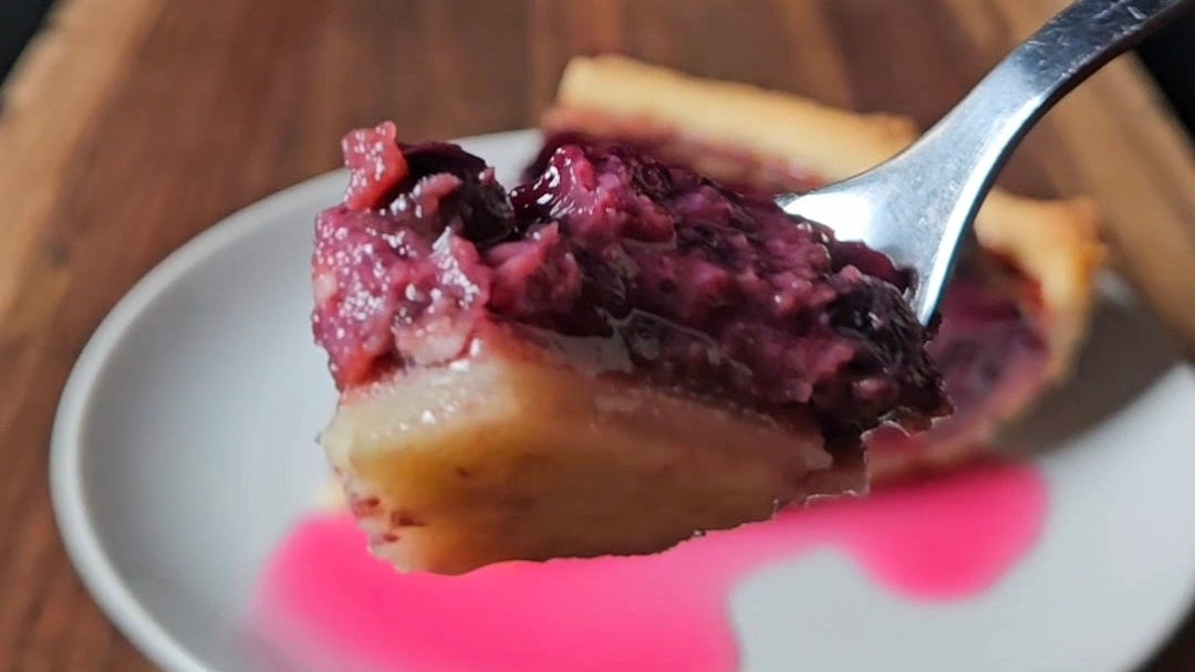 Spoonful of dessert with blueberry amazake filling on a plate with a dark background
